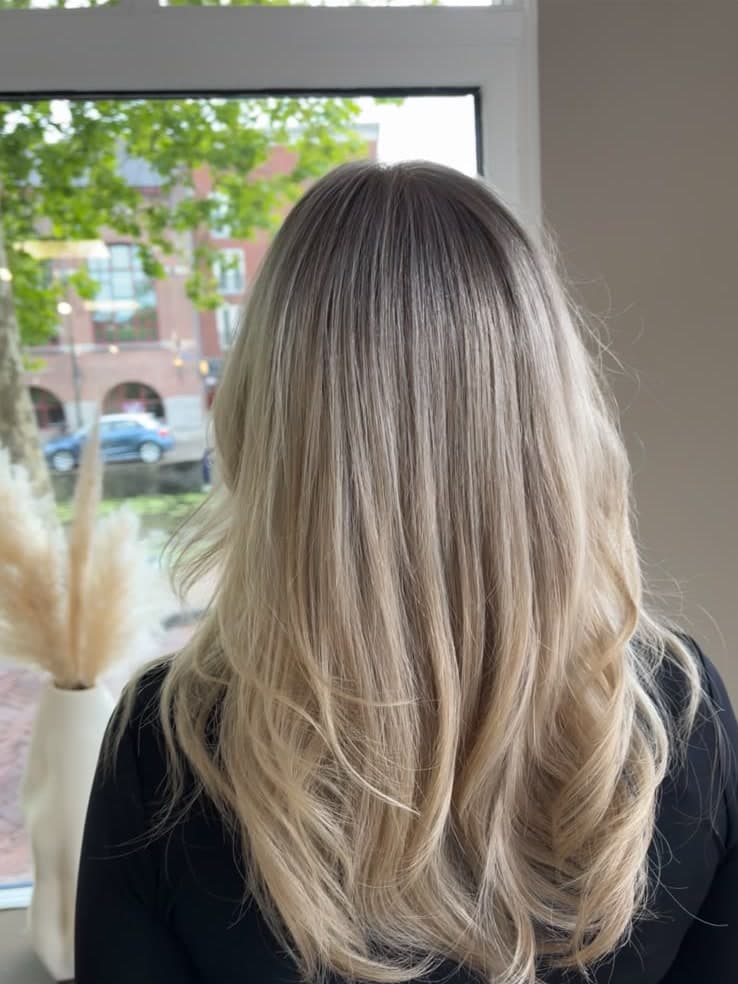 Licht blond haar met zachte uitgroei, gemaakt bij kapper in Gouda