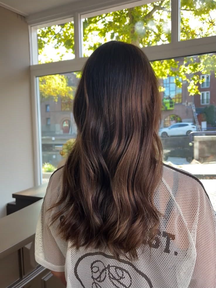 Warm bruin haar met zachte slag, gemaakt in de salon aan de Lage Gouwe